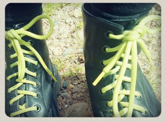 Doc Marten boots with lemon-yellow laces photographed from above on a walk.